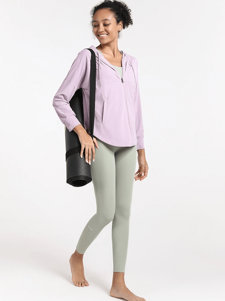 Woman wearing Quick Dry Loose Casual Training Hoodie with Zipper holding a yoga mat, perfect for running, yoga, and fitness.